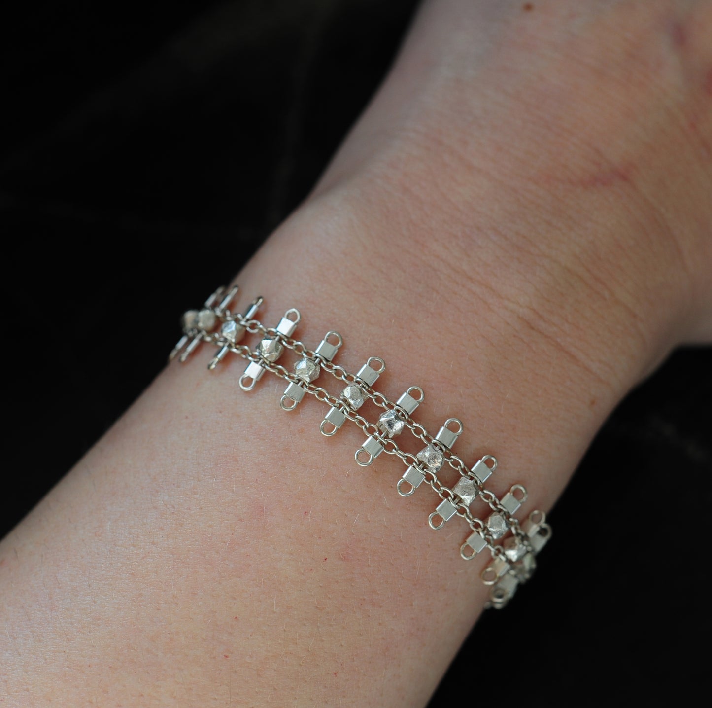Artemis bracelet, featuring faceted, sterling silver beads suspended on sterling rungs and chain, finished with a lobster clasp. Approximately 7 inches in length.