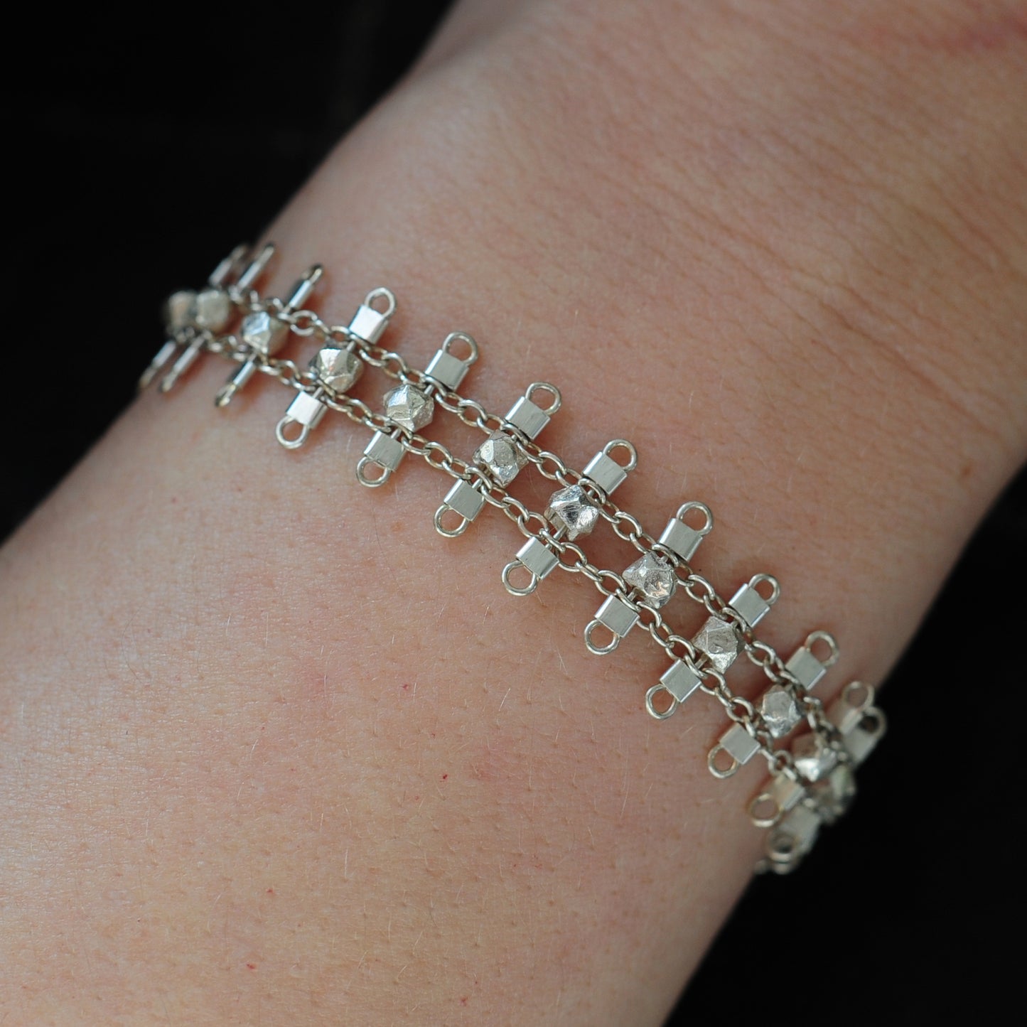 Artemis bracelet, featuring faceted, sterling silver beads suspended on sterling rungs and chain, finished with a lobster clasp. Approximately 7 inches in length.
