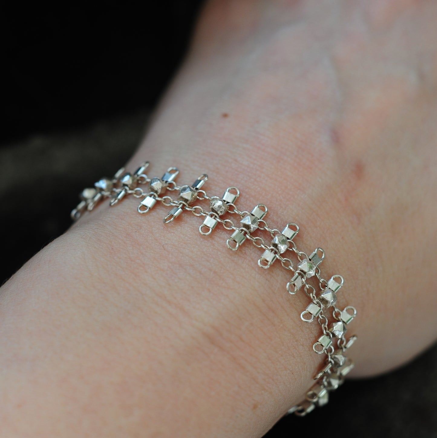 Artemis bracelet, featuring faceted, sterling silver beads suspended on sterling rungs and chain, finished with a lobster clasp. Approximately 7 inches in length.