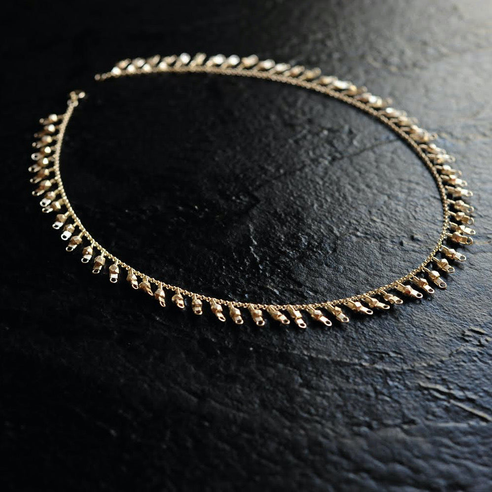 A sterling silver fringe-style necklace of silver faceted beads dangling off a silver chain all the way around.