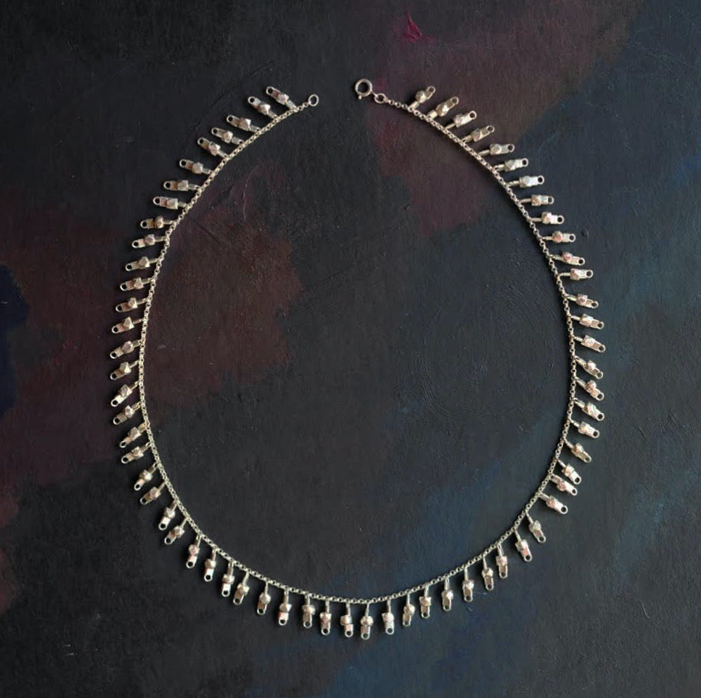 A sterling silver fringe-style necklace of silver faceted beads dangling off a silver chain all the way around.